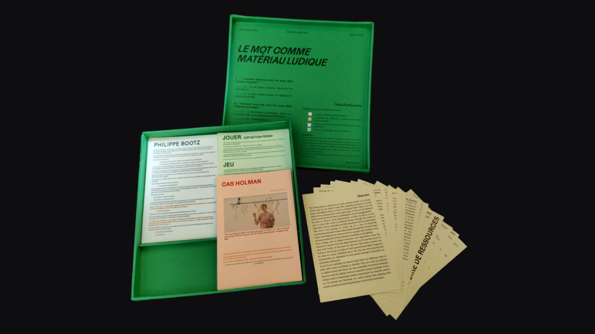 The box is open, it is also green inside. The lid of the box is printed with the &ldquo;rules&rdquo;. The box contains 4 different piles of coloured card, each being a section of the thesis.